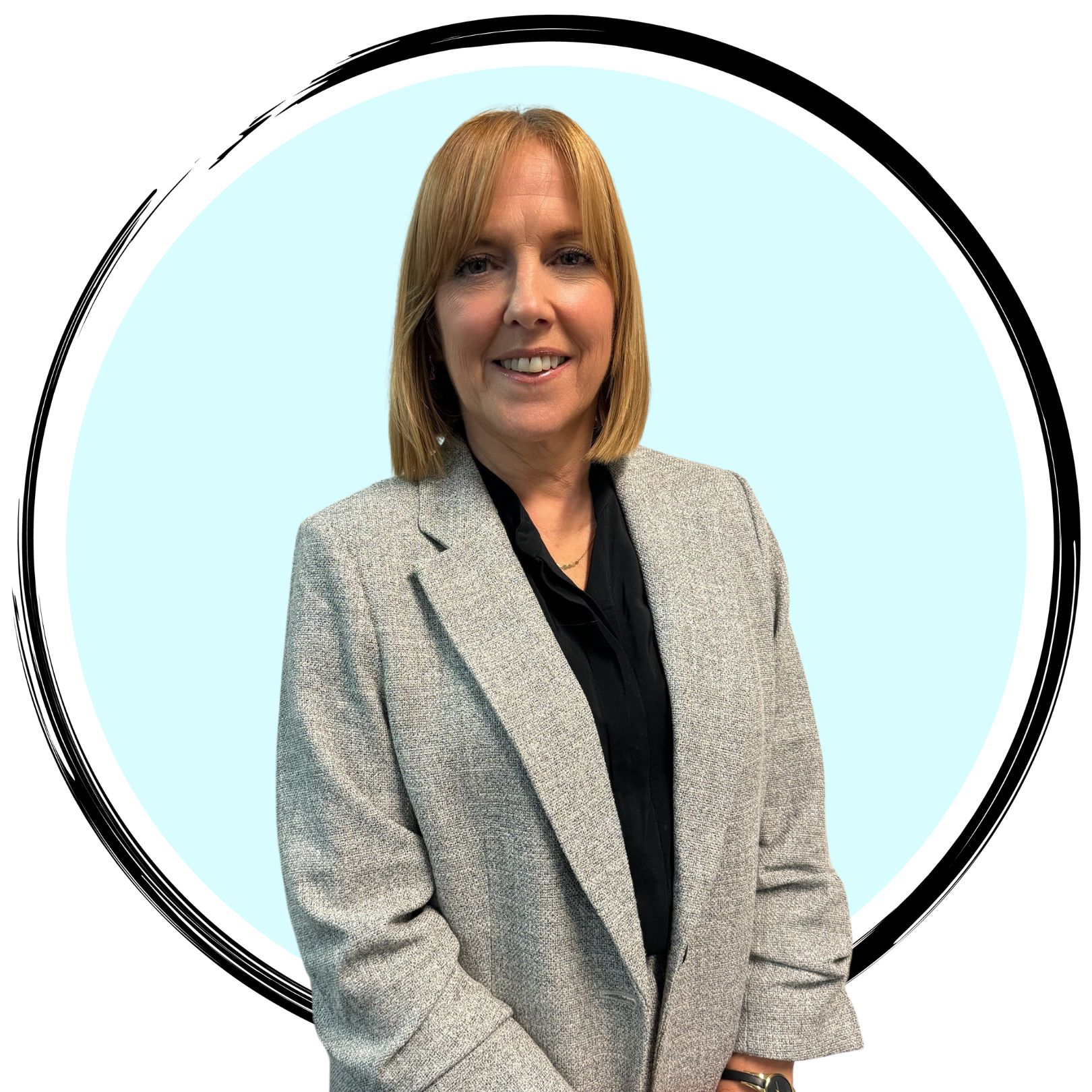 A woman with shoulder-length blonde hair, wearing a light grey blazer over a black top, stands against a light blue circular background with a black border. She has a slight smile and her hands are loosely clasped in front of her.